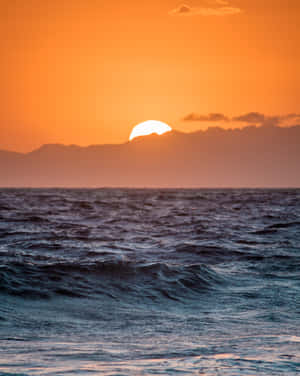 海上日落，遠方有山 — 海灘日落 壁紙