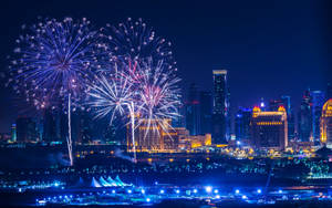 煙火在夜晚燈火通明的城市上空綻放。