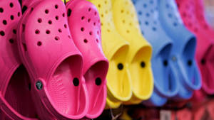 一排色彩繽紛的Crocs鞋在商店中展示。 — 卡通鞋子 壁紙