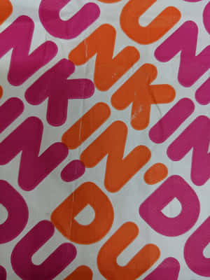 白色布料上粉紅色和橙色抽象字母的對角線圖案。 — Dunkin Donuts 壁紙