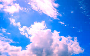明亮的藍天，帶有蓬鬆的粉紅色和白色雲朵。 — 藍色美學電腦 壁紙