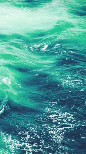 藍綠色海浪的特寫，白色泡沫在運動中旋轉。 — 淺綠色系 壁紙