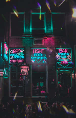 夜晚霓虹燈照亮的酒吧和運動酒吧，人群和色彩繽紛的光線。 — Infinix Xpad GT 壁紙