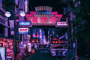 夜晚霓虹燈照亮的東京街道，發光的招牌和潮濕的人行道反射出五彩繽紛的燈光。 — 東京 壁紙