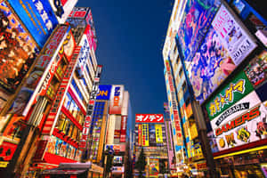 夜晚的東京街道被色彩繽紛的霓虹燈和動漫海報照亮。 — 街頭 壁紙