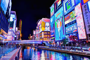 夜間東京運河，發光的霓虹燈倒映在水中。