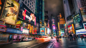 夜晚繁忙的城市街道，發光的廣告牌和汽車燈光劃過。 — 紐約 壁紙