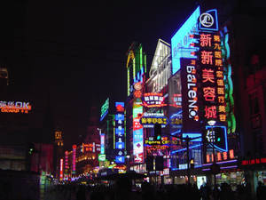 夜晚的城市街道，充滿發光的霓虹燈牌和人群。 — 霓虹燈 壁紙