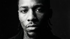 黑白特寫肖像，一個有刺青的男人，眼神強烈。 — Lil Durk 壁紙