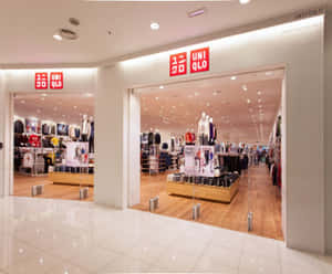 Uniqlo 服裝店入口，帶有紅色標誌和木地板。 — 白天 壁紙