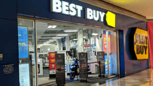 Best Buy電子產品商店入口，配有玻璃門和促銷展示。 — 最佳購買 壁紙
