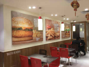 速食店內有紅色椅子和牆上大型食物海報。 — 漢堡王 壁紙