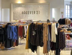 Forever 21服裝店，有服裝架和閃亮的牆壁標誌。 — 永遠21 壁紙