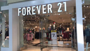 Forever 21服裝店，透過玻璃門可見人體模型和促銷標誌。 — 永遠21 壁紙