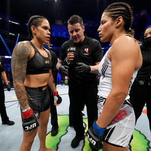兩位女性MMA拳手在八角籠中面對面站立，裁判拿著麥克風。 — 運動 壁紙
