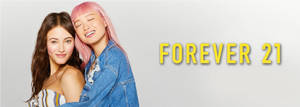 兩位年輕女性微笑，一位粉紅色頭髮靠著另一位，靠近Forever 21標誌。