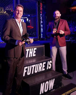 兩位UFC評論員在舞台上，身後有「The Future Is Now」階梯。 — 終極格鬥冠軍賽 壁紙