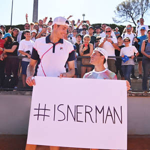 兩位網球選手舉著 #ISNERMAN 標語牌，身後有歡呼的粉絲。 — 運動 壁紙
