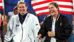 兩位微笑的網球選手在雨中行走，身後有美國國旗。 — 溫布頓 壁紙