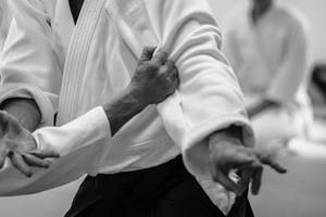 兩位穿著道服的武術家在訓練中進行纏鬥技術。 — 運動 壁紙
