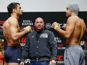 兩位UFC拳手在稱重時對峙，Iron Mike Tyson在中間。 — 終極格鬥冠軍賽 壁紙