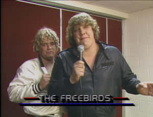兩位摔角手在後台，一人手持麥克風，帶有文字疊加 The Freebirds — 摔角 壁紙