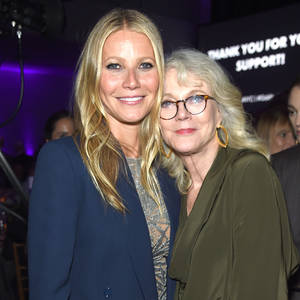 兩位女性在紫色燈光下的正式活動中一起微笑。 — 好萊塢 壁紙