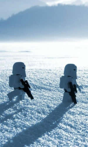 兩個 LEGO 雪地兵團在藍天下深雪中行走。 — 酷炫iPhone 壁紙