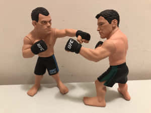 兩個UFC拳手人偶在白色表面上擺出戰鬥姿勢。 — 運動 壁紙