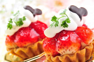 兩個草莓塔，上面放有鮮奶油和巧克力心。 — 糕點 壁紙