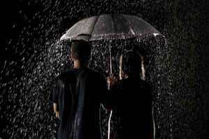 兩人在夜間大雨中一起撐傘。 — 情侶 壁紙