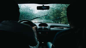 雨中行車時車內的兩個人，從後座觀看。 — 5120x2880 壁紙