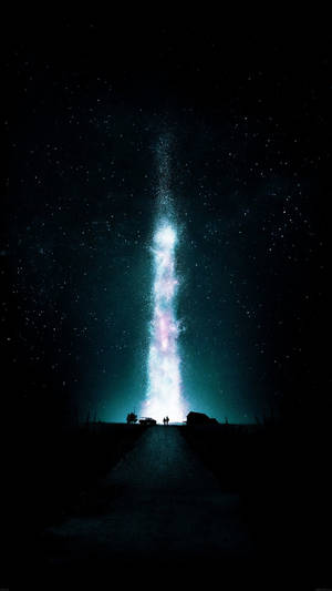 兩個人在路上仰望夜空中的垂直星系。
