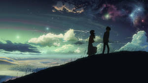 在發光星雲的星空下，山丘上的兩個剪影人物。 — 深色主題 壁紙