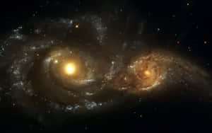 兩個螺旋星系在深空中碰撞，帶有發光的核心和星場。 — 星星 壁紙