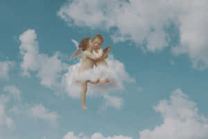 兩個天使在天空中的雲朵上以充滿愛意的擁抱漂浮。 — 天使 GIF 壁紙