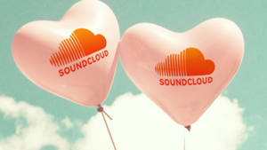 兩個帶有 SoundCloud 標誌的粉紅色心形氣球，在藍綠色天空和雲朵中飄浮。 — Soundcloud 壁紙