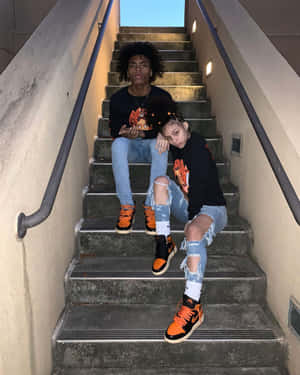 兩個穿著街頭服的年輕人在混凝土樓梯上擺姿勢。 — 可愛情侶 壁紙