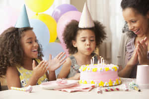 孩子們吹熄生日蠟燭，大人在附近拍手。 — 生日快樂蛋糕 壁紙