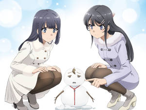 兩個穿著冬季外套的女孩在雪景中與一個小雪人玩耍互動。 — 櫻島麻衣 壁紙