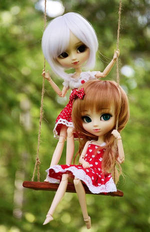 兩個穿著紅色連衣裙的 Blythe 娃娃在綠色森林中的木鞦韆上。 — 芭比美人魚 壁紙