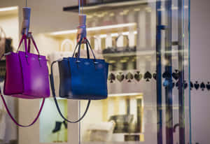 兩個色彩繽紛的手提包掛在精品店櫥窗中。 — Kate spade 壁紙