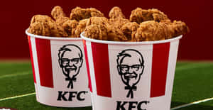 兩個裝滿炸雞的KFC桶在足球場上。 — 薯條 壁紙