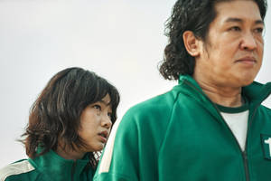 兩個身穿綠色號碼運動服的人眺望遠方。 — 067 魷魚遊戲 壁紙