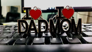 電腦鍵盤上的兩個 I heart DAD 和 I heart MOM 鑰匙圈。 — 爸爸 壁紙