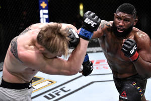 兩名男性拳手在UFC鐵籠內於比賽中交換強力一拳。 — 終極格鬥冠軍賽 壁紙