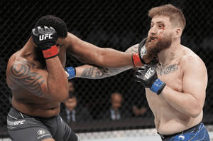 兩名男性MMA拳手在UFC八角鐵籠比賽中互相出拳。 — 終極格鬥冠軍賽 壁紙