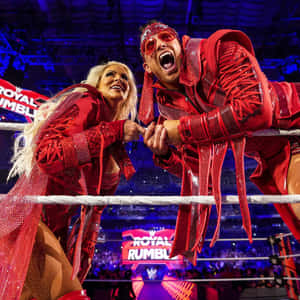 WWE摔角手穿著紅色服裝在皇家大戰活動期間在擂台上慶祝。 — 八重神子 壁紙