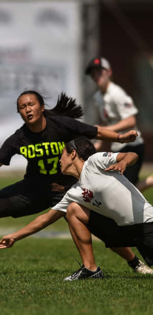 兩名女子極限飛盤選手在陽光明媚的日子裡在草地上比賽。 — 運動 壁紙
