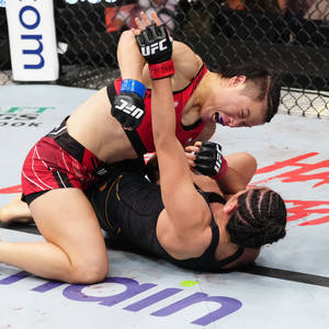 兩名女性拳手在UFC比賽中於墊上纏鬥。 — 1:1 壁紙